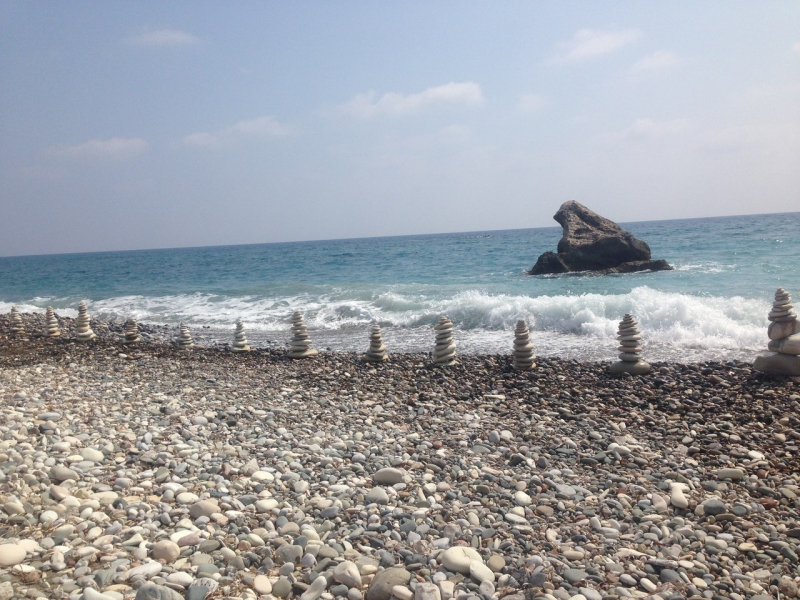 Пирамидки из камней на счастье, на диком пляже в Петра-ту-Ромиу