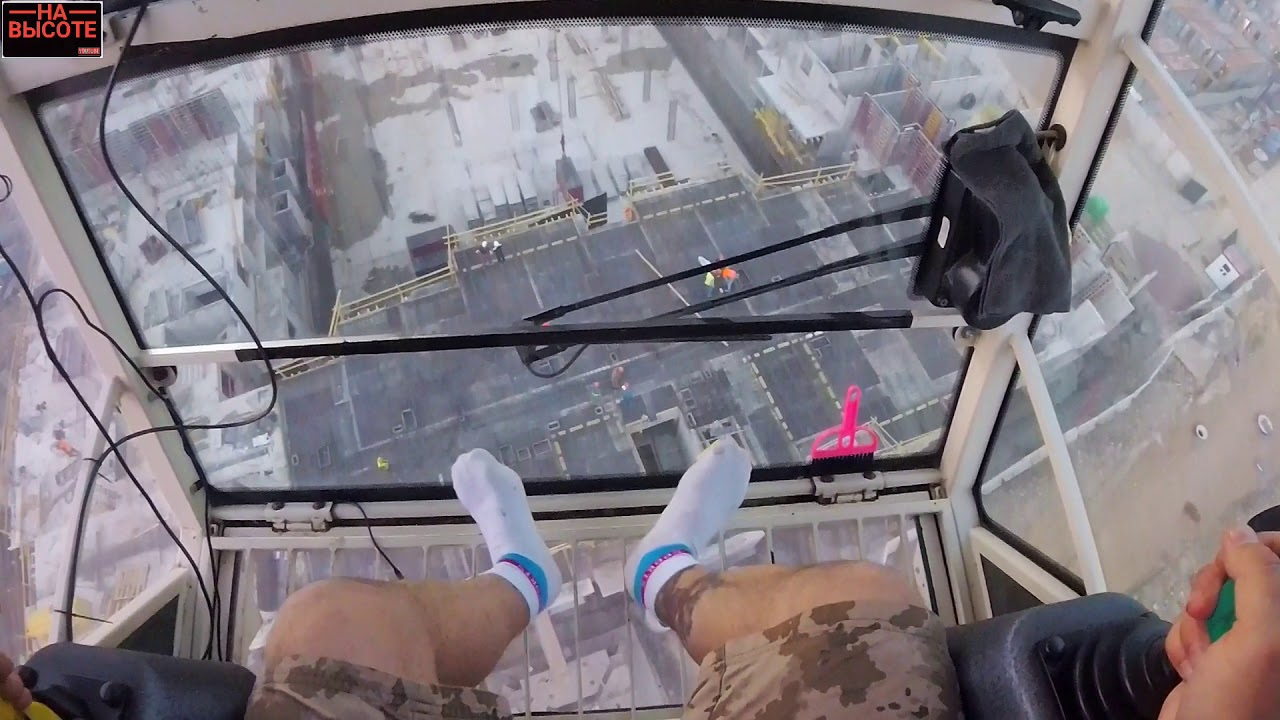 Крановщик во время шторма на башенном кране. Crane operator during a storm on a tower crane.