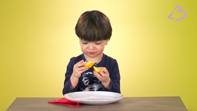 Дети едят лимон